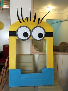 a cardboard cut out of a yellow and blue minion with big eyes on it's head