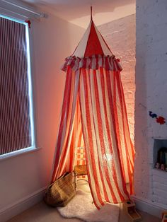 a red and white striped canopy bed in a room