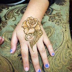 a woman's hand with a rose tattoo on it