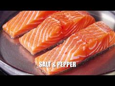 three pieces of salmon sitting on top of a frying pan with salt and pepper