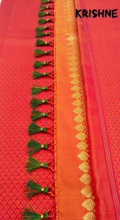 two rows of orange and green sari with tassels on the ends, one is