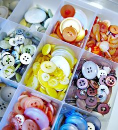 a box filled with lots of different types of buttons in it's compartments on top of a table