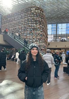 a woman standing in the middle of a library