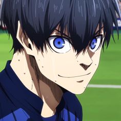 a close up of a person with blue eyes and black hair on a soccer field