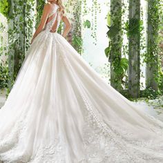 a woman in a white wedding dress standing next to an archway with ivy growing on it