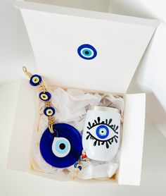 an evil eye mug and keychain in a white box with blue glass beads