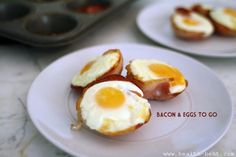 two white plates topped with eggs and bacon