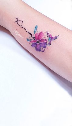 a person with a tattoo on their arm that has flowers and the word love written in cursive writing