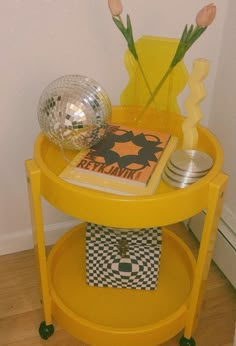 a yellow table with flowers and magazines on it