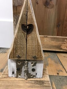 a wooden birdhouse with a heart on it's face