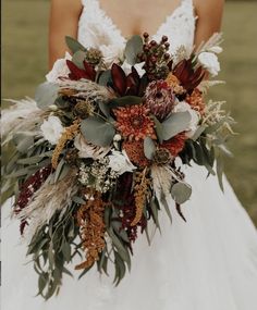 a bridal holding a bouquet of flowers and greenery