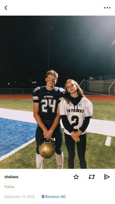 a man and woman posing for a photo on a football field