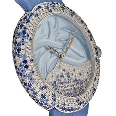 La Calatrava Haute Joaillerie Réf. 4899/901 se décline désormais dans une palette de tons bleus, à l'allure ultra-féminine. Les contours légèrement arrondis du boîtier en or blanc sont sertis de rangées de diamants en quinconce, entrecoupées de saphirs aux couleurs plus ou moins intenses. SERTISSAGE 98 diamants : ~0,23 ct. 89 saphirs bleus : ~0,28 ct. (cadran). 149 diamants : ~1,1 ct. 182 saphirs bleus : ~1,93 ct. (cas). 36 diamants : ~0,04 ct. 1 cabochon saphir bleu : ~0,1 ct. (couronne). 65 di Patek Philippe Calatrava, Patek Philippe Watches, Breitling Navitimer, Classic Watches, Rolex Day Date, Rolex Daytona, Omega Speedmaster, Pearl Diamond, Royal Oak