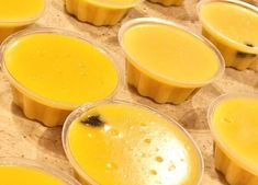 several cups filled with yellow liquid sitting on top of a counter