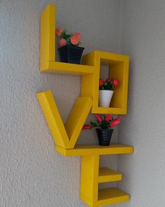 two yellow shelves with flower pots on each shelf and the word love painted on them