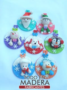 there are many small christmas ornaments in the shape of santa claus and penguins on top of snowflakes