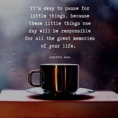 a coffee cup sitting on top of a wooden table next to a rain covered window