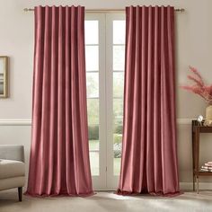 a living room with pink curtains and furniture