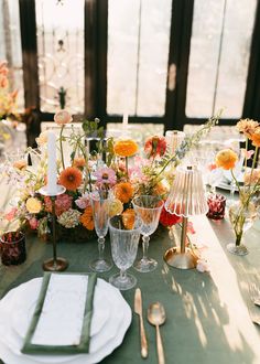 the table is set with flowers, candles and silverware for an elegant wedding reception