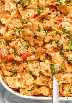 a casserole dish filled with pasta and meat, garnished with parsley