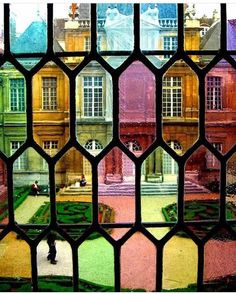 the view through a stained glass window into a courtyard