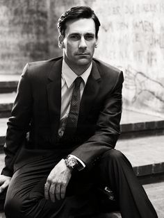 a man in a suit and tie sitting on steps