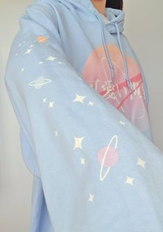 "\"Kawaii Sekai\" which translates to \"Cute World\" is a Harajuku & NASA inspired design, with both sleeves printed with pastel colored planets and stars. If space was pink, and planets were filled with cute things, would you like to visit? ('* ω  ♡ Printed via Direct-to-Garment method for a matte finish that blends well with the fabric without excess edges. American sizing! Size chart on the last image. ❤ 50% pre-shrunk cotton, 50% polyester ❤ Air-jet spun yarn with a soft feel and reduced pil Kawaii Blue Cotton Hoodie, Blue Cotton Kawaii Hoodie, Blue Harajuku Cotton Sweatshirt, Blue Cotton Harajuku Sweatshirt, Cute Blue Hoodie With Cartoon Print, Pastel Outfits Aesthetic, Cute Pastel Outfits, Pastel Hoodie, Planets And Stars