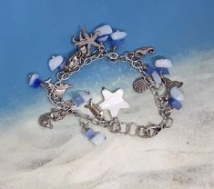 Women charm bracelet, chain, lobster clasp bracelet,  chip beads, white shell star, beach theme, women or girls,  silver and blue, handmade, beach, ocean Made with love by aunt lu Silver Starfish Charm Bracelet For Beach, Silver Charm Bracelet With Starfish For Beach, Beach Ocean-inspired Charm Bracelet, Silver Charm Bracelet With Lobster Clasp For Beach, Silver Charm Bracelet For The Beach, Blue Charm Bracelets For The Beach, Handmade Blue Charm Bracelet For Beach, Handmade Silver Charm Bracelet For Beach, Adjustable Ocean-inspired Charm Bracelet With Lobster Clasp