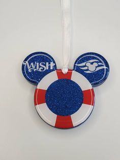 a mickey mouse ornament hanging on a white wall with a red and blue life preserver