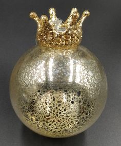 a silver vase with a gold crown on top