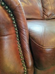 a brown leather couch with green beads on it