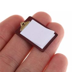 a small piece of paper is held in the palm of someone's hand with a clip