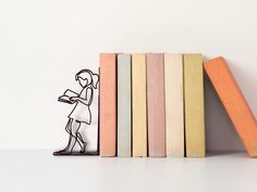 there is a book shelf with books on it and a woman standing next to them