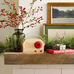 an old radio sitting on top of a mantle next to a vase filled with flowers