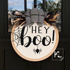 a door hanger with the words hey boo on it and a spider in front