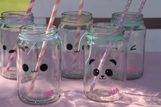 four mason jars with panda face straws in them