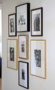 a wall with many pictures hanging on it's side and some framed photos in the middle