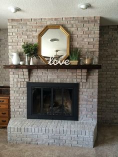 a brick fireplace with a mirror above it and some plants on the mantels