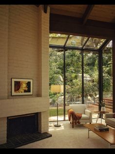 a living room with a fireplace and glass walls