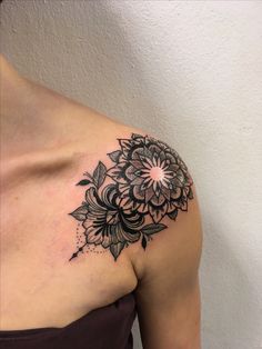 a black and white flower tattoo on the shoulder