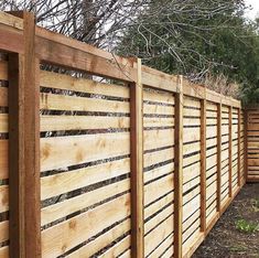 a wooden fence is shown in front of some trees