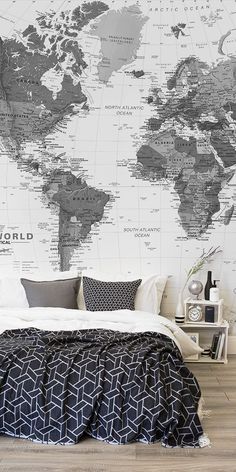 a bedroom with a large world map on the wall and bed in front of it