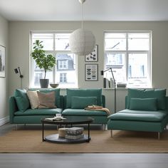 a living room with two couches and a coffee table in front of large windows