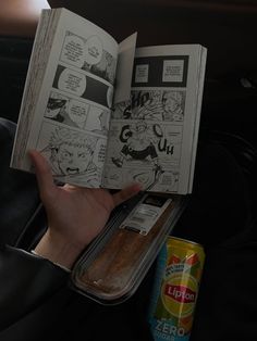 a person holding an open comic book in their hand