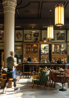 a man walking past a bar with lots of chairs