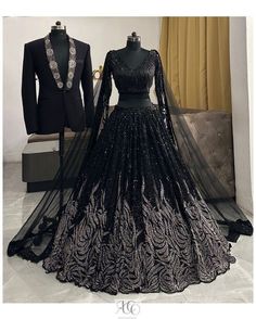 two mannequins are dressed up in black and silver gowns, one is wearing