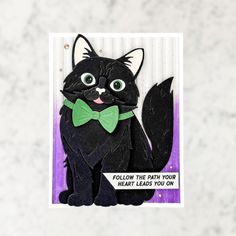 a card with a black cat wearing a green bow tie