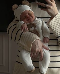 a woman holding a baby in her arms and taking a selfie with the phone