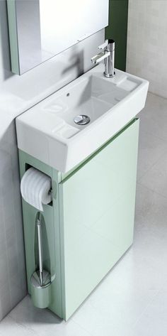 a bathroom sink sitting under a mirror next to a toilet paper dispenser