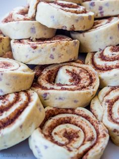 cinnamon rolls are piled on top of each other in a pile and ready to be eaten